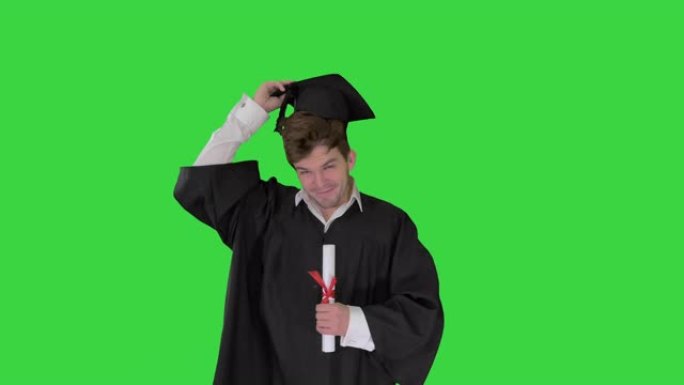 男毕业生微笑着把帽子扔在绿色屏幕上，色度键