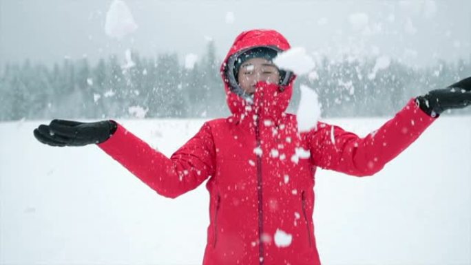 年轻的亚洲妇女在白雪皑皑的公园玩得开心