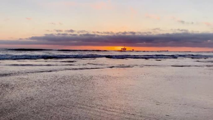 从亨廷顿海滩 (Huntington Beach) 可以欣赏到海上石油钻机平台上的壮丽日落