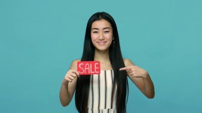 正面的亚洲女性，一头黑发，手里指着单词买卖，推荐折扣