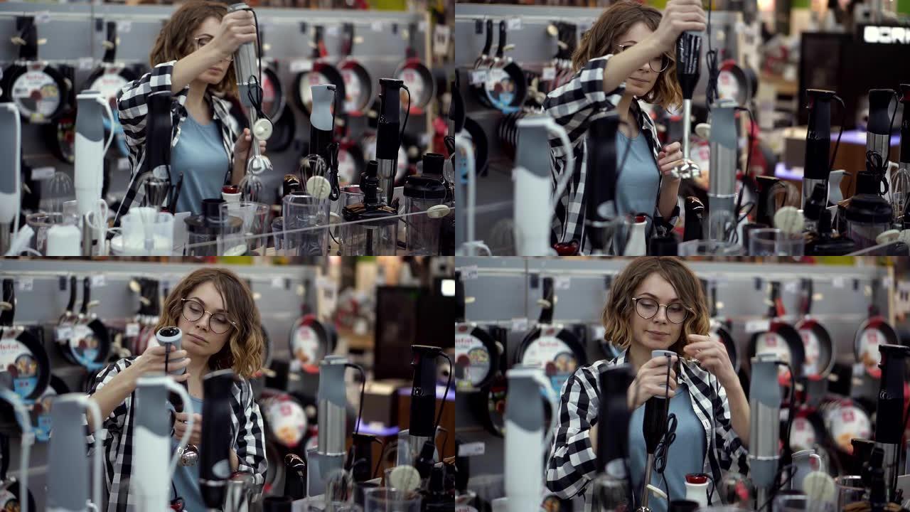 在电器商店中，一位穿着格子衬衫的迷人卷发女人通过查看并握住手中的设备来选择搅拌器棒。慢动作