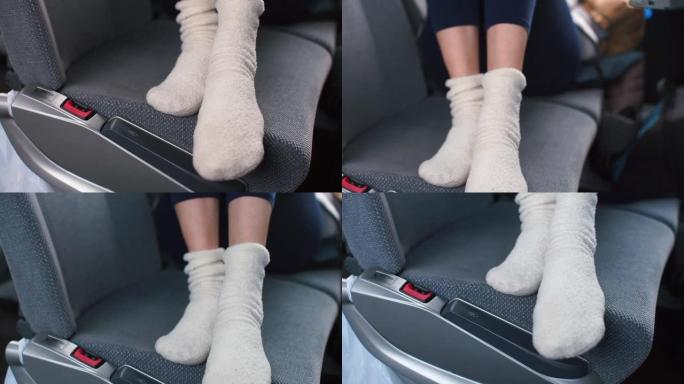 穿着白色袜子的腿的特写镜头躺在公共汽车的乘客座位上。