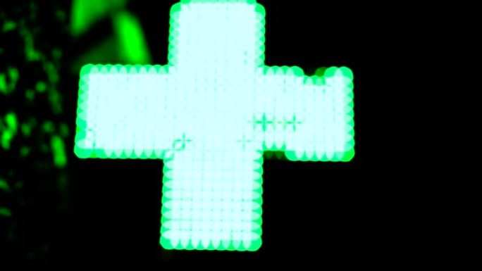 照明绿色制药十字。药房街道标志。