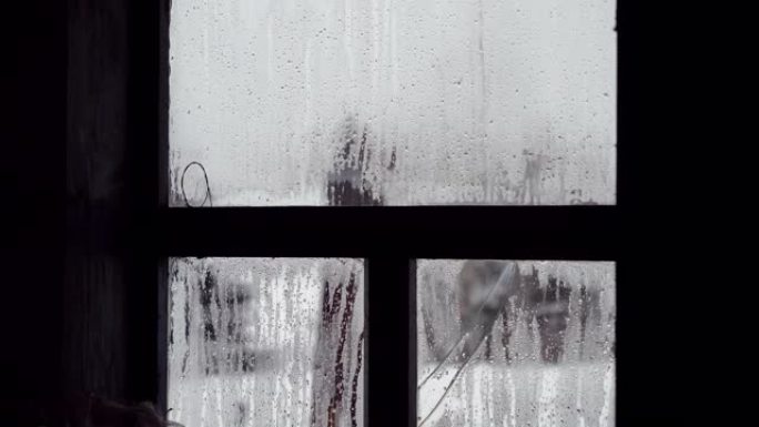 俄罗斯老房子破碎的窗户玻璃上的水滴特写镜头。4K