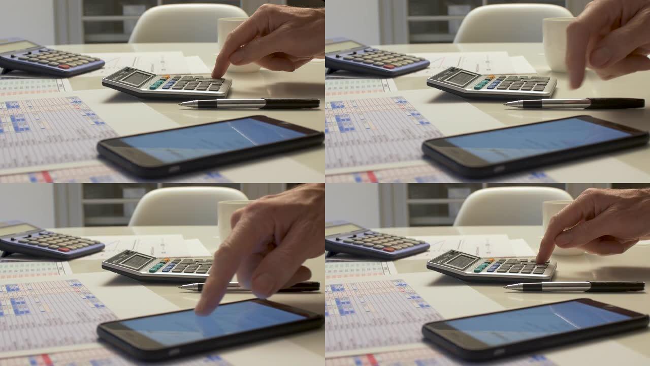 用计算器做账的人在桌面上做账。