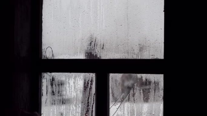 关闭俄罗斯乡村房屋中破碎的窗户玻璃上凝结的水滴。4K
