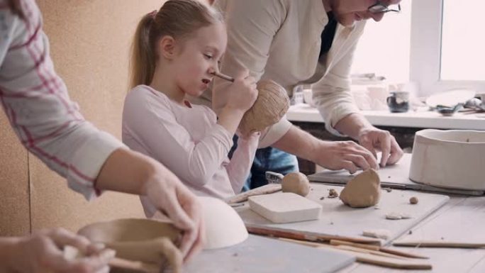 两个成人陶艺家人和小女孩制作陶器obj