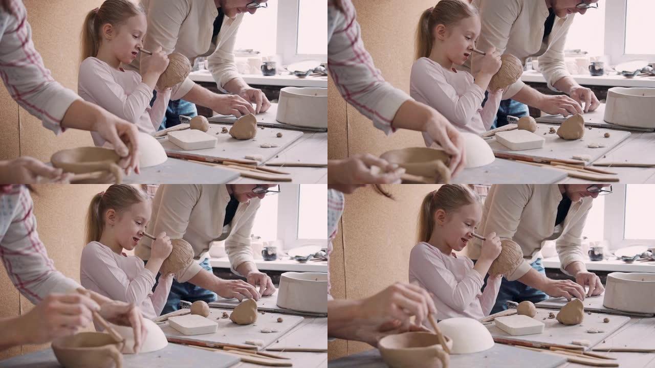 两个成人陶艺家人和小女孩制作陶器obj