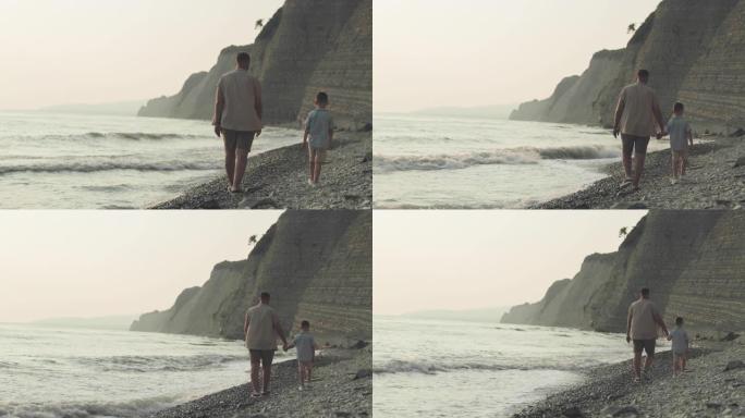 一个男人和一个男孩沿着卵石滩散步的背景图