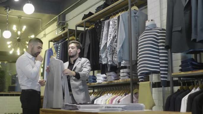 拉丁美洲男人在裁缝店选择衬衫 (慢动作)