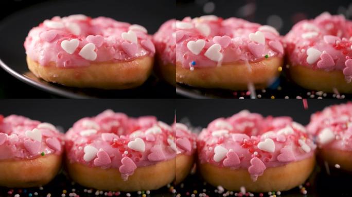 洒水落在粉红色甜甜圈上，带有心形洒水-滑动镜头