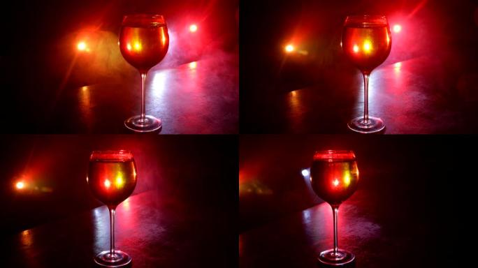 木桌上的酒杯，背景上有美丽的调色灯。深色背景上的一杯葡萄酒。选择性聚焦。俱乐部饮料概念。滑块镜头