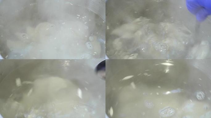 煮汤。搅拌勺子汤。液体碟子。锅在厨房的炉子上。沸水上升蒸汽。