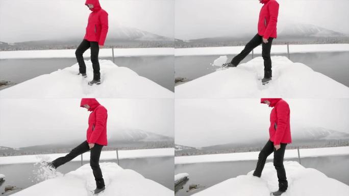 女人在朱红色湖踢雪球