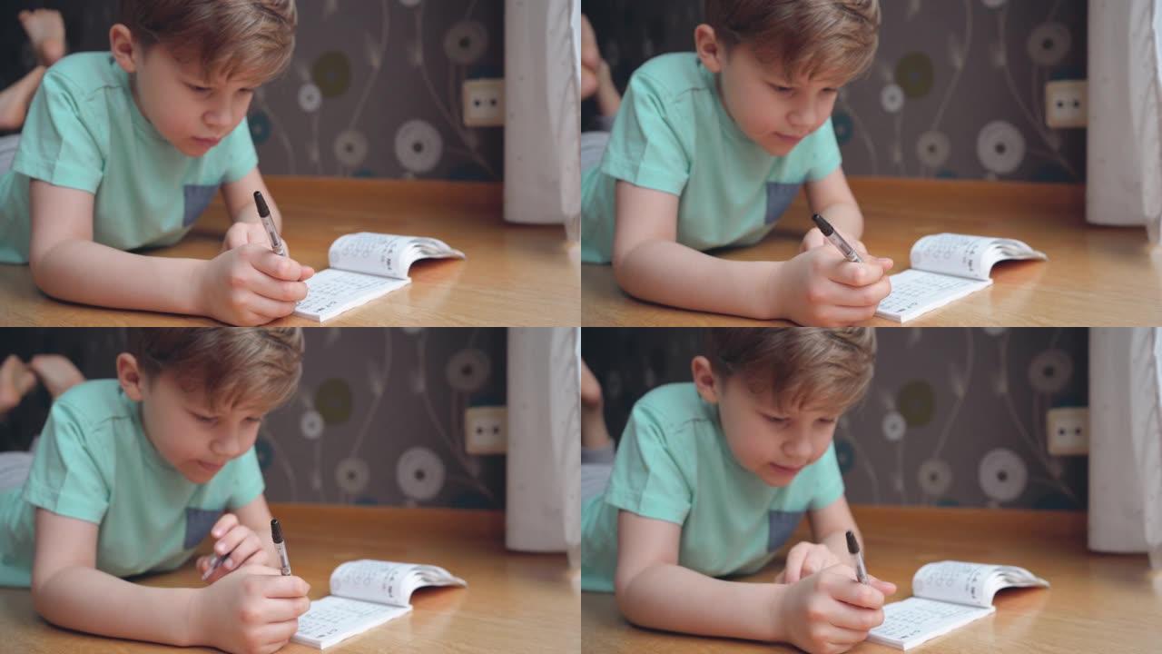 男孩集中注意力思考。孩子在笔记本上学习作业和写作。做数学。