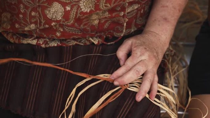 高级高加索女性编织篮在工艺车间。女人双手制作工艺品的特写视频