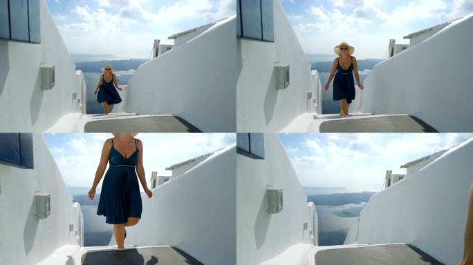 穿着绿色连衣裙和太阳帽的幸福女人在希腊圣托里尼岛享受假期。从伊梅罗维格利看破火山口和爱琴海。