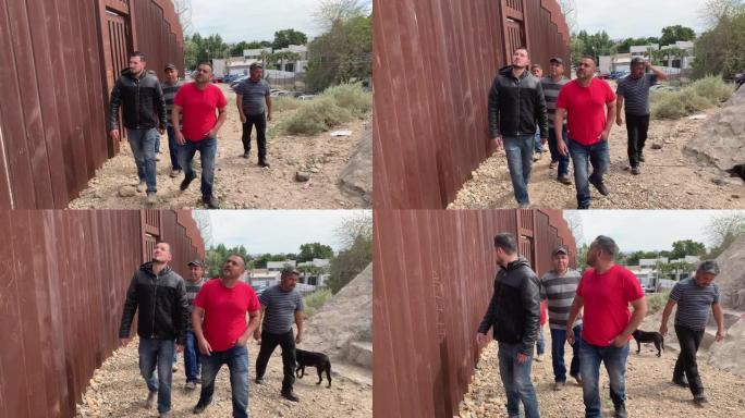 一群四名墨西哥男子站在墨西哥尤马亚利桑那州边境的边境围栏附近