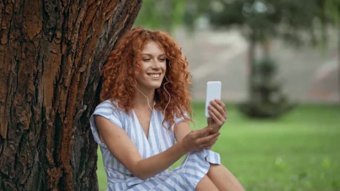 快乐的红发女孩在智能手机上有视频通话