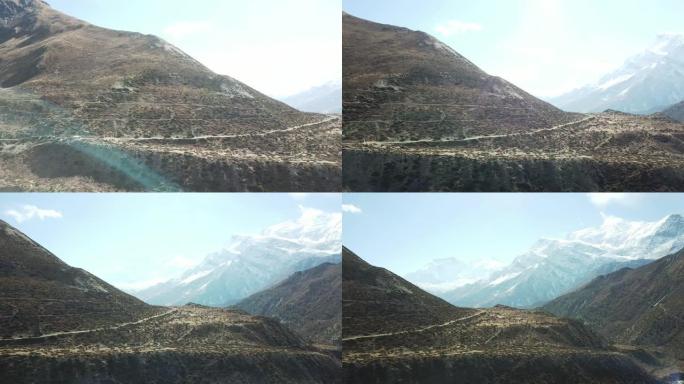 尼泊尔喜马拉雅山马南谷全景照片。山谷中有一条小河。周围的高山。贫瘠的斜坡，中间有一些灌木丛。安纳普尔