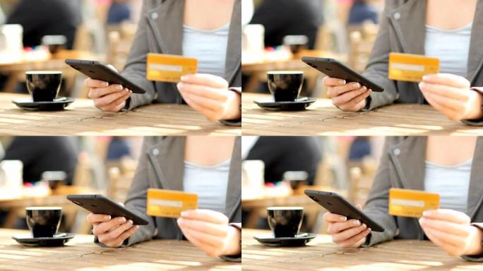 女人在咖啡馆里用电话和信用卡付款
