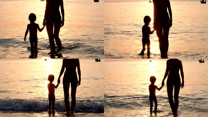 有孩子的女人站在海滩上的水中