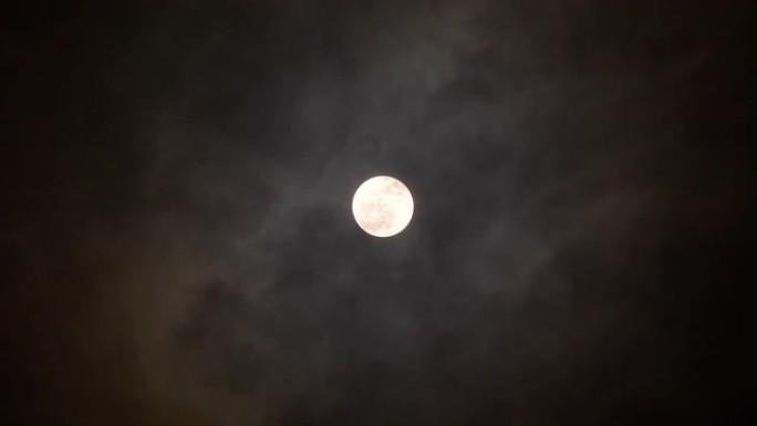明亮的满月，夜晚有移动的云背景，4k镜头，月光照亮的云。