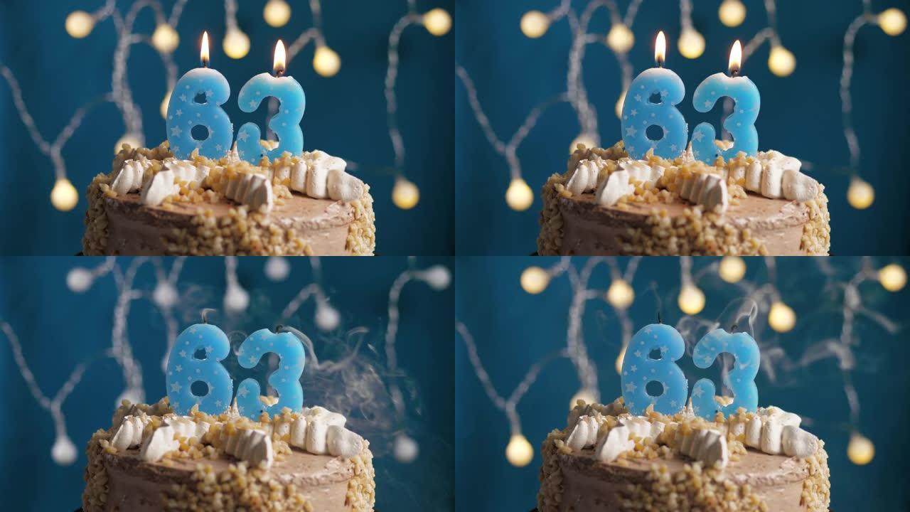 蓝色背景上有63号蜡烛的生日蛋糕。蜡烛吹灭了。慢动作和特写视图