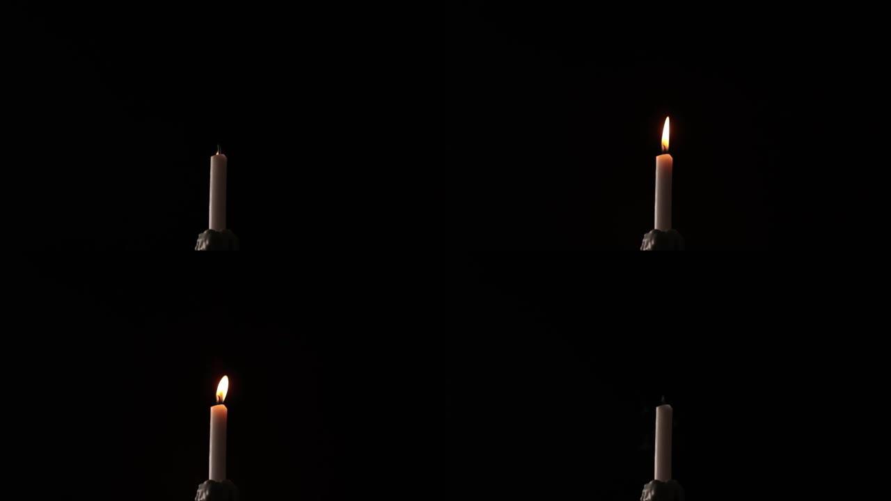 阵风试图熄灭黑色背景上的蜡烛。