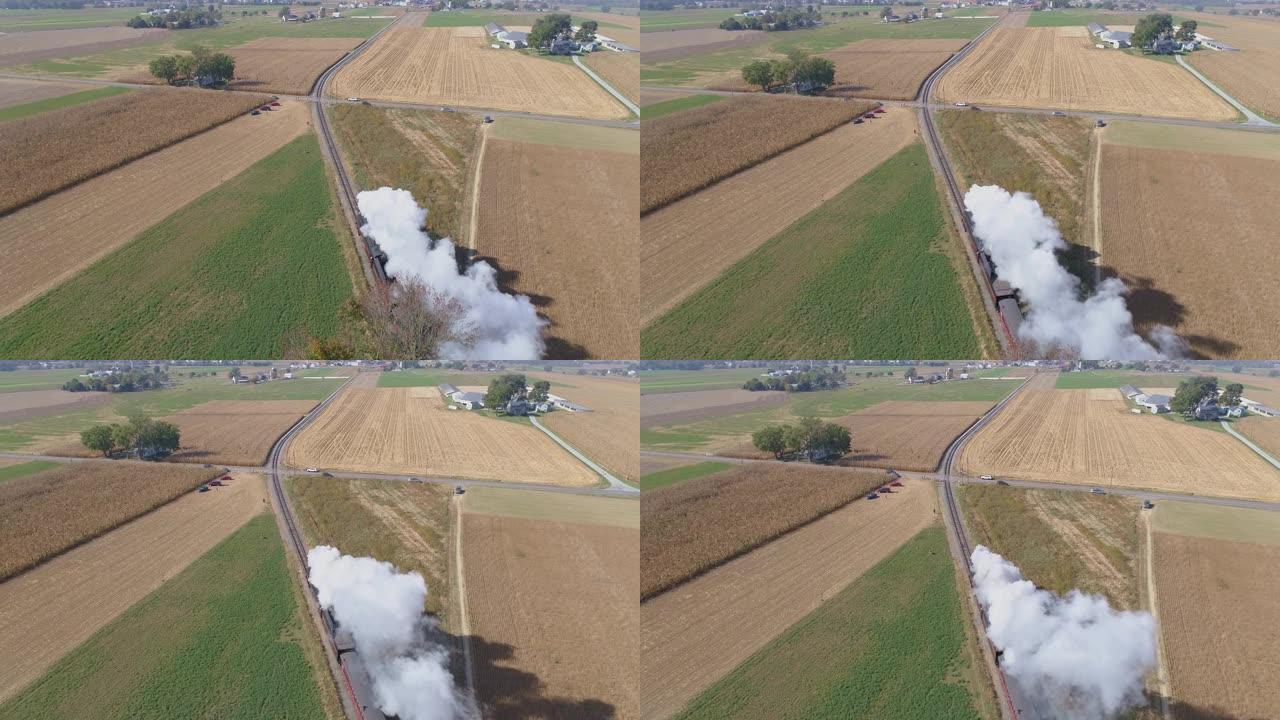 从头顶看，蒸汽火车吹着烟雾和蒸汽沿着乡村行驶的鸟瞰图