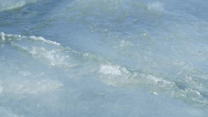 近距离拍摄的浮冰片相互磨碎，并在海面上融化。