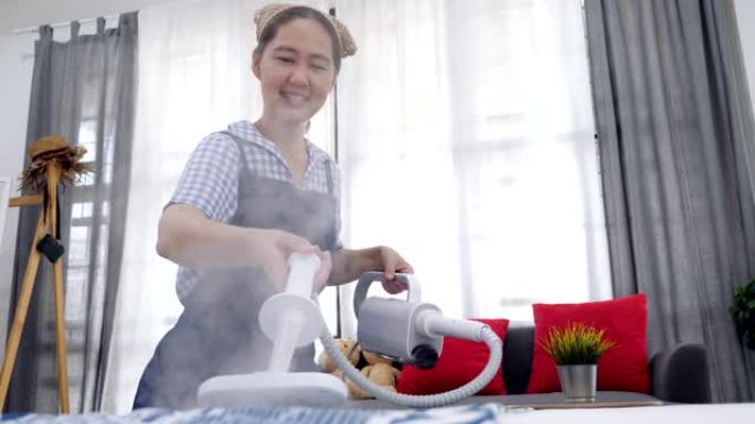 慢动作拍摄亚洲妇女清洁卧室与蒸汽蒸汽清洁剂，家庭主妇清洁房子良好的家庭保健