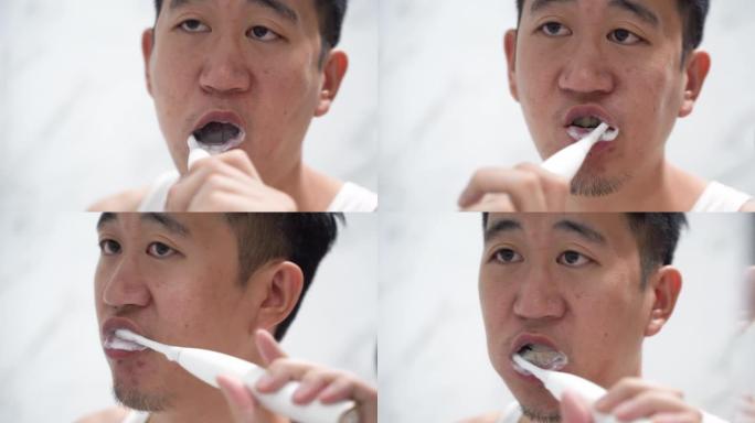 亚洲男子使用电动牙刷清洁牙齿