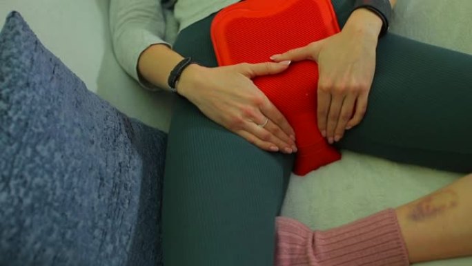 女孩在肚子上放了一个温暖的加热垫，以缓解经前综合症的症状。