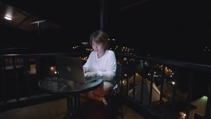 年轻的亚洲妇女在寄宿家庭使用笔记本电脑
