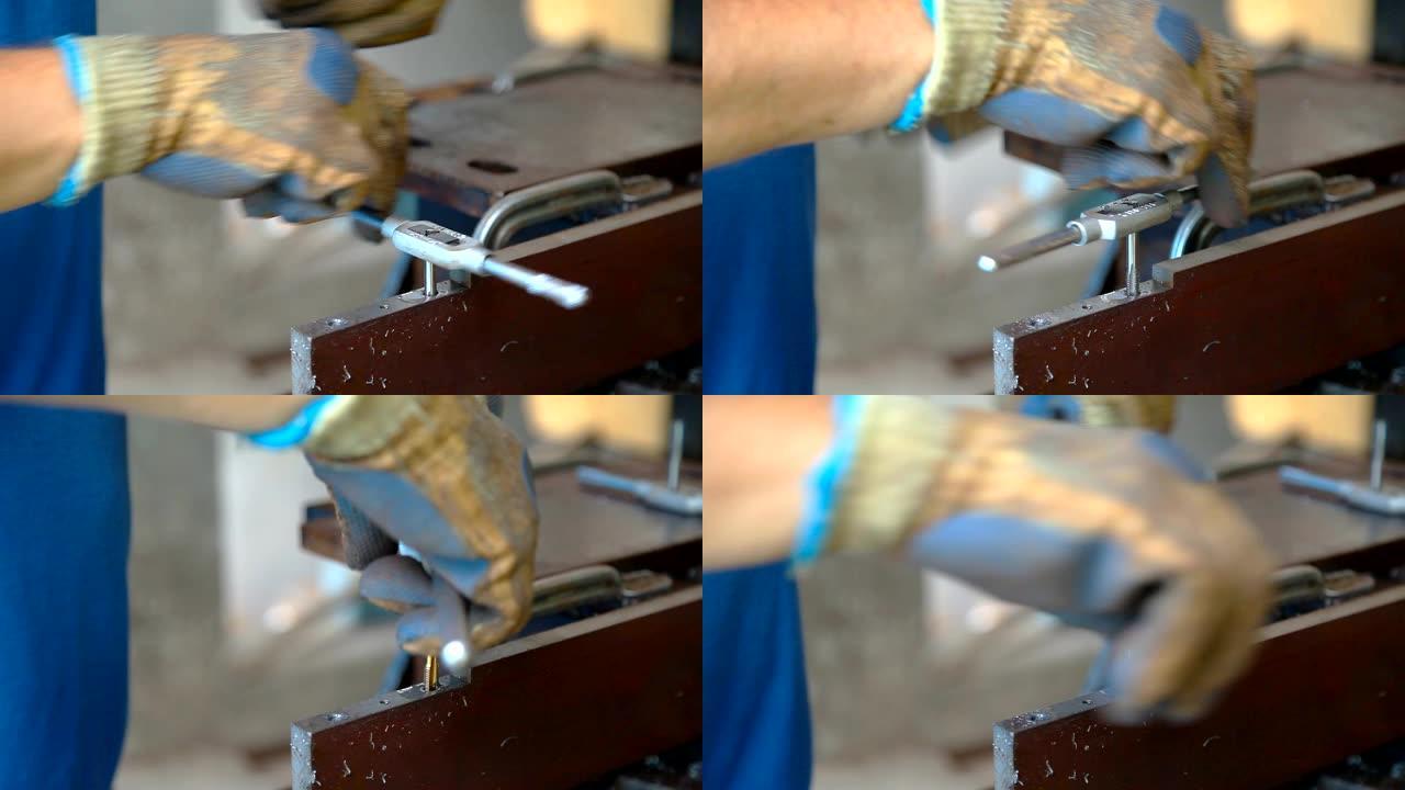 一名戴着防护手套的男子在金属上剪了一根线，以备将来连接。