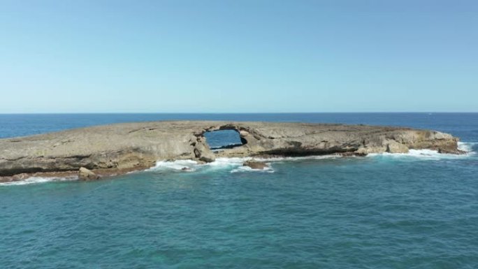 无人机飞向夏威夷瓦胡岛Laie Point的海上拱门小岛