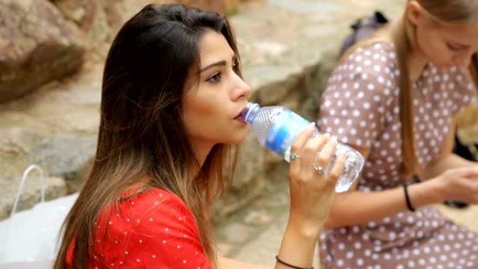 女人用塑料瓶喝水外国女人户外喝水补水