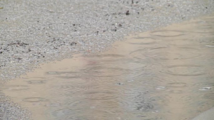 Rain on asphalt or tarmac road creating ripples, h