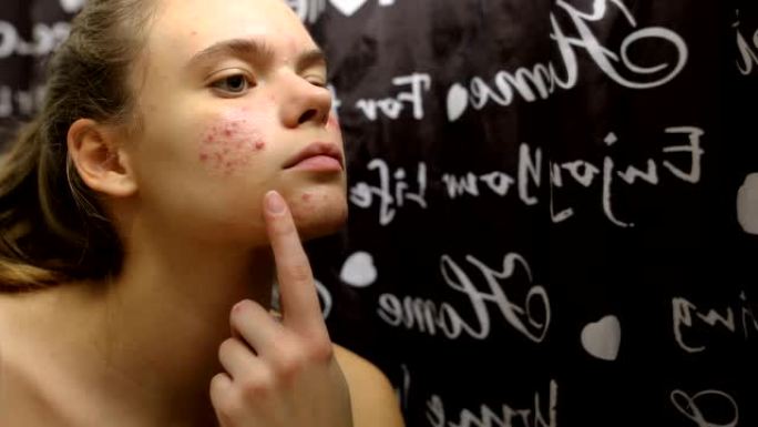 十几岁的女孩在浴室的脸上涂抹精油