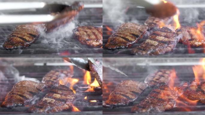 酋长用钳子把肉放在烤架上。多汁、肥腻的油炸肉。牛肉是在大火上油炸的。框架里有很多火和烟。特写慢动作