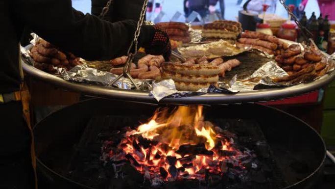 不同类型的烤香肠在一个大锅里用明火油炸。街头咖啡馆为博览会上的游客准备款待。