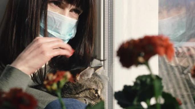 病毒。一个女人正坐在猫的病毒防护纱布面具。