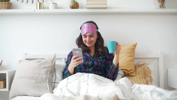 女人早上在床上使用智能手机