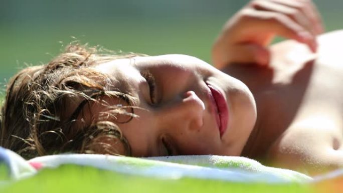 孩子躺在阳光下的草地上