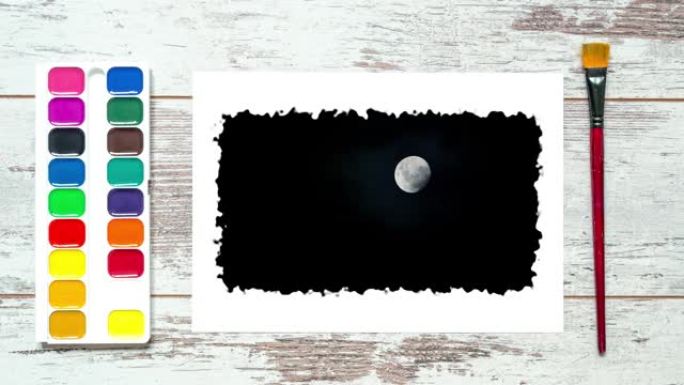 创意延时视频4k的老式桌子用刷子，一组五颜六色的油漆，一张纸，这张纸是满月，夜空中有快速移动的云。3