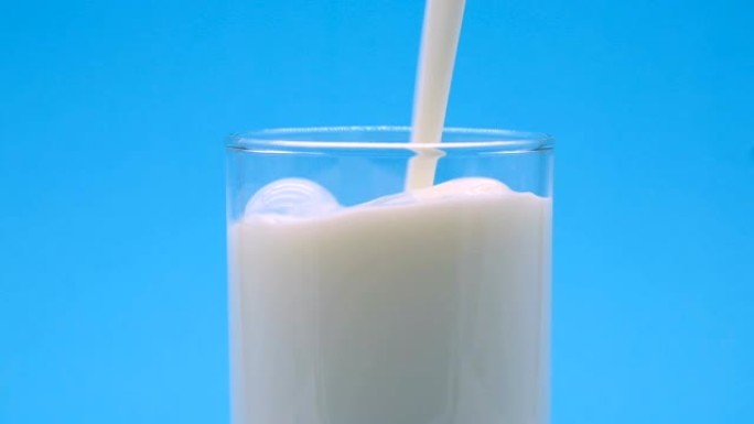 牛奶蓝幕背景倒入纯牛奶羊奶