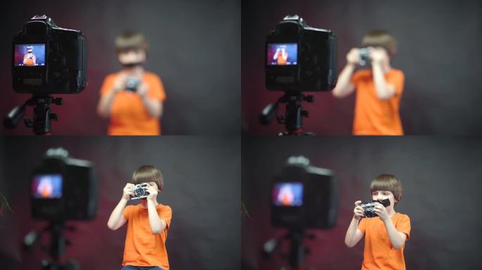 一个穿着橙色衣服的男孩，脸上贴着胶带，记录了有关相机的视频。
