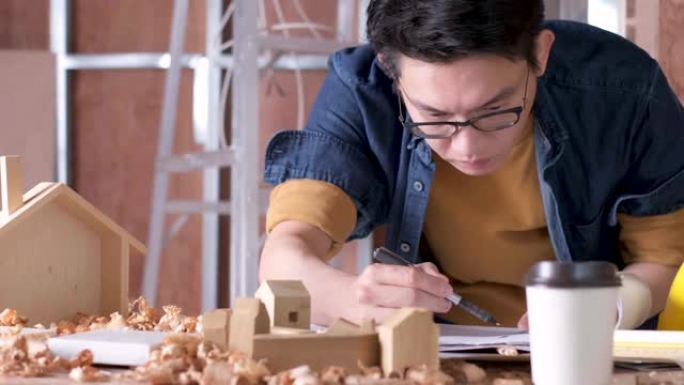 聪明迷人的方便眼镜亚洲男性工匠或室内设计师焦点木材在现场施工家庭室内设计房屋翻新和改进概念
