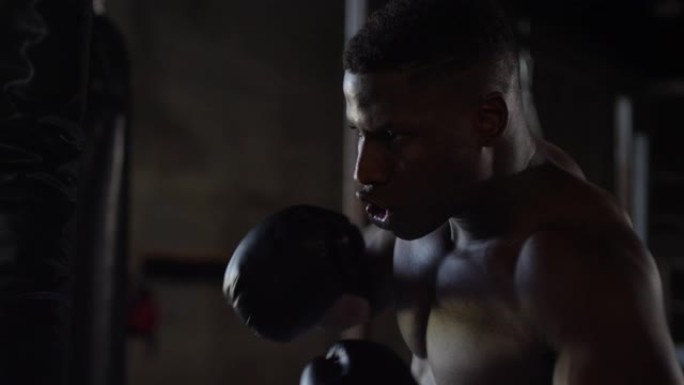 非裔美国拳击手在慢动作中用大左钩击中沉重的包